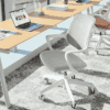 edit office ux mesh chair in white side facing towards a desk with a laptop in an office environment