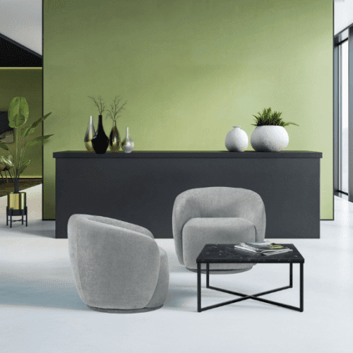 two grace lounge chairs in warm grey next to a table posed in front of a black unit with plant decorations