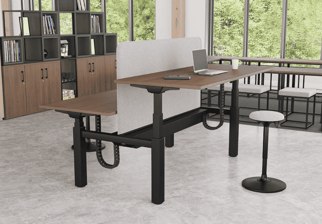 Employee using a height-adjustable desk to alternate between sitting and standing for improved health