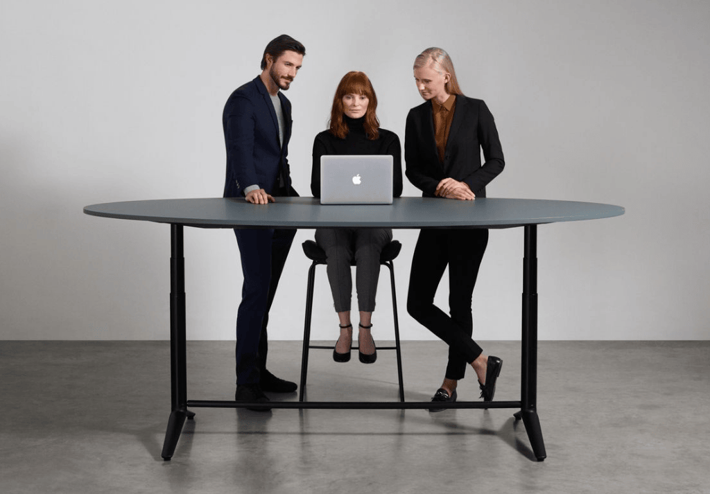 Team collaborating at height-adjustable desks in a modern open-plan office