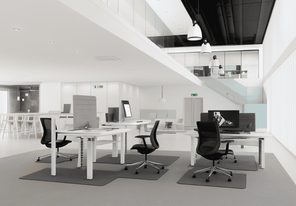 Employee using height-adjustable desk with anti-fatigue mat and ergonomic accessories