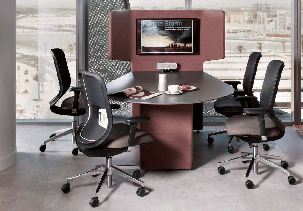Employee working at a desk using an ergonomic office chair with adjustable lumbar support and breathable mesh back.