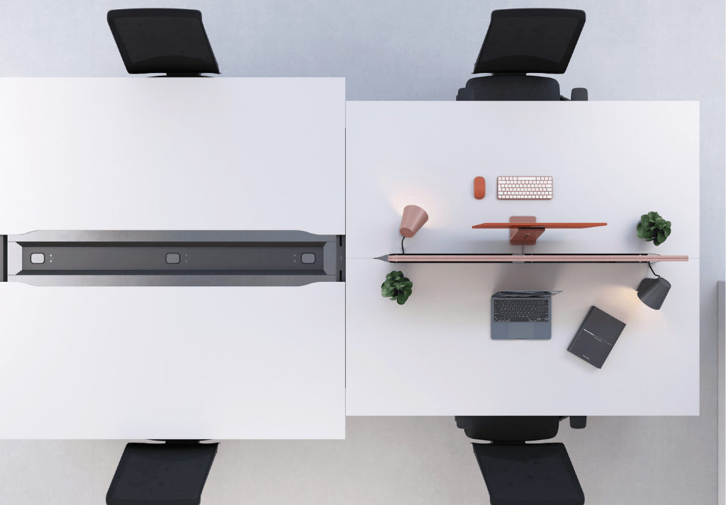 Close-up of office desk with under-desk cable tray, monitor arm, and tidy wiring