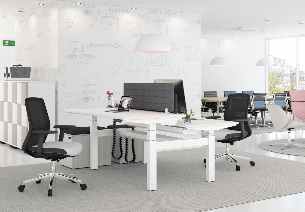 Modern office with height-adjustable standing desks and employees alternating between sitting and standing