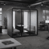 Zum office pod in dark grey office space surrounded by office furniture