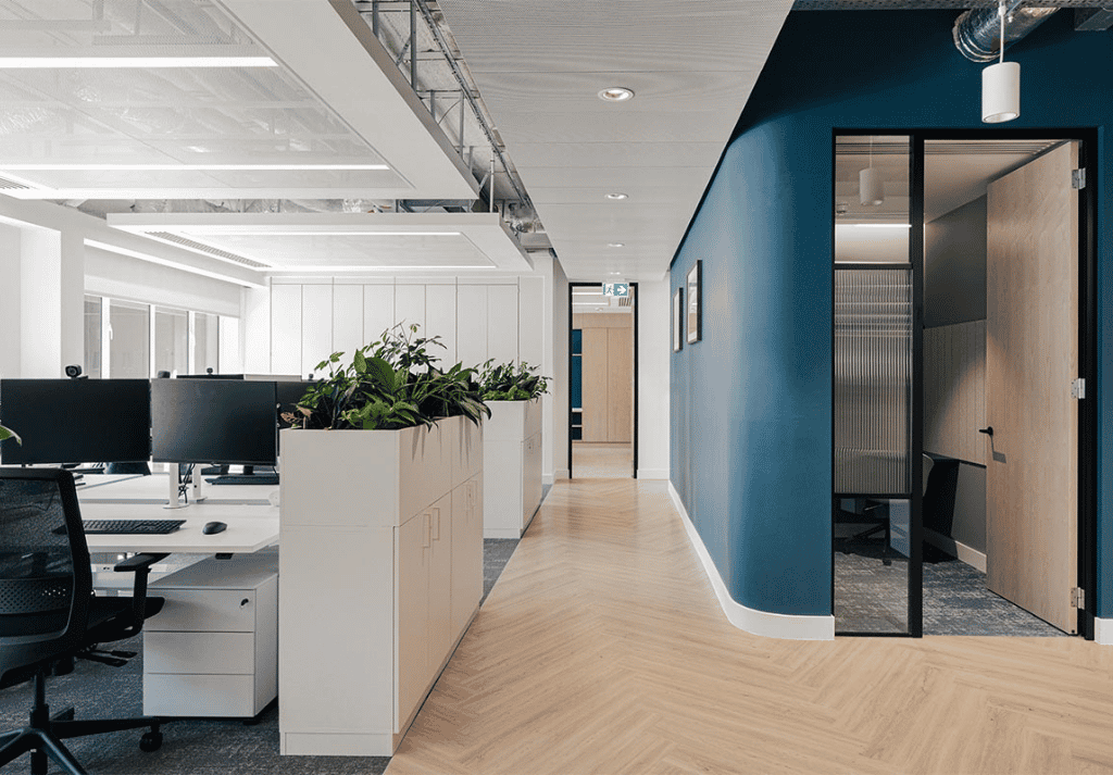 Modern open plan office with ergonomic desks, natural lighting and collaborative working environment