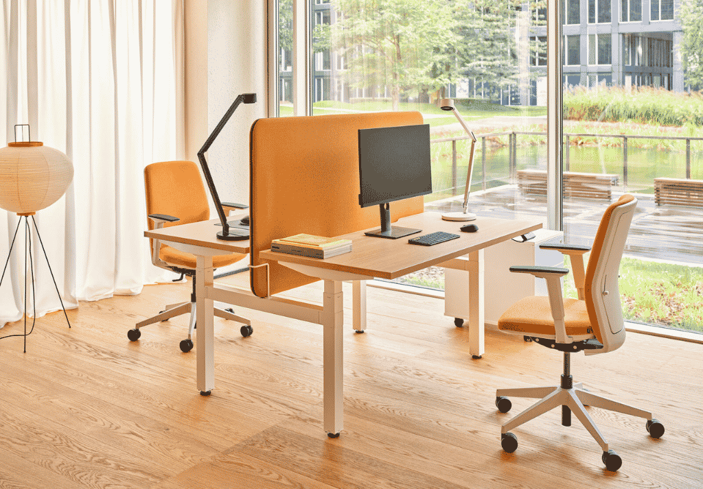Close-up of ergonomic office workstation showing adjustable chair, monitor setup and organised desk space